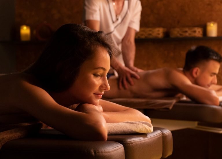 Photo by Sergey Torbik A couple enjoys a relaxing massage in a warm, candle-lit spa environment, providing ultimate relaxation.